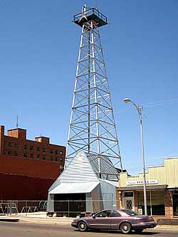 Exterior of the oil museum -- with a steel derrick standing beside it.