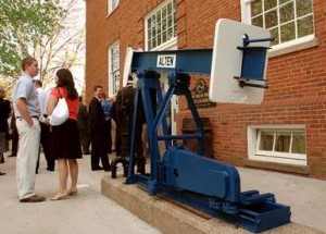 Pumpjack on display in from of building.